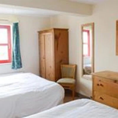 An Creagán (2 bedroom) – Tornoge - bedroom with twin beds with drawers and wardrobes